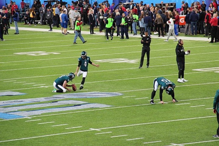 Players kick a ball in the Super Bowl.
